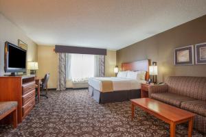 a hotel room with a bed and a couch and a television at Holiday Inn Express Casper I-25 by IHG in Casper