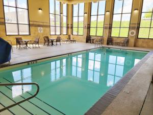a large swimming pool with chairs and tables in a building at Holiday Inn Express Casper I-25 by IHG in Casper