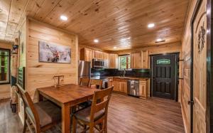 a kitchen with a table and chairs in a cabin at Smoky Mountain Cabin, Sleeps 12, 2 Kitchens & Hot Tub in Pigeon Forge