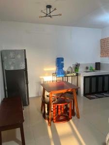 a kitchen with a table and chairs and a refrigerator at Vin's Transient WiFi Netflix City Hall-DRMC-EPark in Tagum +10 photos