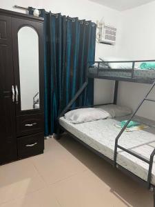 a room with two bunk beds and a mirror at Vin's Transient WiFi Netflix City Hall-DRMC-EPark in Tagum
