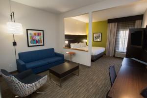 a hotel room with a blue couch and a bed at Holiday Inn Express Wilmington by IHG in Wilmington