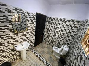 a bathroom with two toilets and a sink at Savannah Lodge in Larabanga
