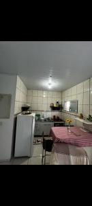 a kitchen with a table and a white refrigerator at Casa verde in Laguna