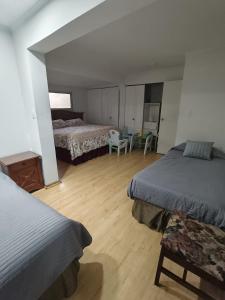 a bedroom with two beds and a table and chairs at Hostal 7 norte Sporting viña del mar in Viña del Mar +14 photos