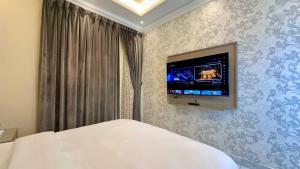 a bedroom with a bed and a tv on the wall at كريستال الخليج للشقق الفندقيه in Kuwait