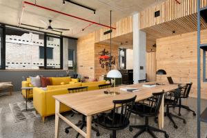 a living room with a yellow couch and a table at Neighbourgood 84 Harrington in Cape Town