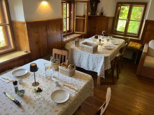 a dining room with two tables with white table cloth at Unterhecherhof in Bannberg