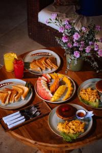 a wooden table with plates of food on it at Isla Única- Islas del Rosario in Isla Grande