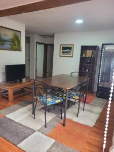 a living room with a wooden table and chairs at Hostal 7 norte Sporting viña del mar in Viña del Mar