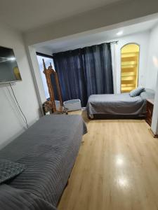 a bedroom with two beds and a wooden floor at Hostal 7 norte Sporting viña del mar in Viña del Mar