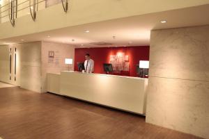 a man standing at a counter in a lobby at Holiday Inn Fortaleza by IHG in Fortaleza +131 photos