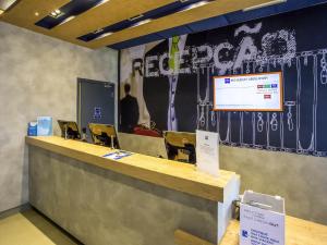 a lobby with a reception desk with a presentation at Ibis Budget Uberlândia in Uberlândia