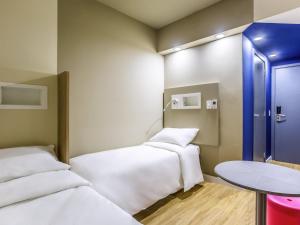 a small room with two beds and a table at Ibis Budget Uberlândia in Uberlândia +90 photos