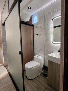 a small bathroom with a toilet and a sink at URBAN suites in Lima