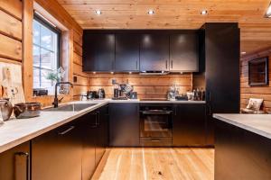 a kitchen with black cabinets and a sink at Idre Luxury Chalet Winter Haven /w Sauna - Happy Rentals in Idre