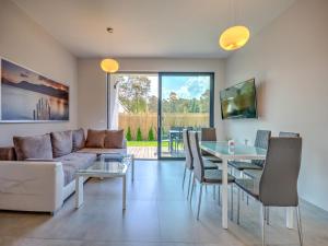 a living room with a couch and a table at Comfortable holiday home with a garden and a pool in Pobierowo