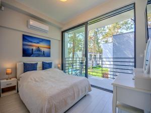 a bedroom with a bed and a large window at Comfortable holiday home with a garden and a pool in Pobierowo