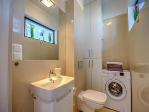 a bathroom with a sink and a washing machine at Comfortable holiday home with a garden and a pool in Pobierowo +24 photos