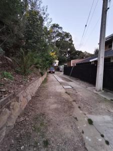 a dirt road with a car parked next to a wall at Hostal 7 norte Sporting viña del mar in Viña del Mar