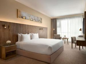 a hotel room with a large bed and a desk at Movenpick Hotel & Residences Hajar Tower Makkah in Mecca