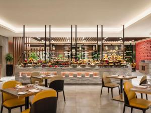 a restaurant with tables and chairs and a bar at Movenpick Hotel & Residences Hajar Tower Makkah in Mecca