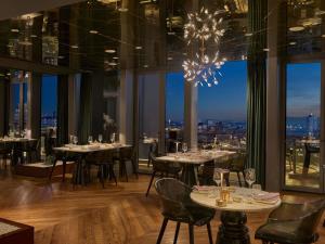 a restaurant with tables and chairs with a view at Fairmont Quasar Istanbul Hotel in Istanbul