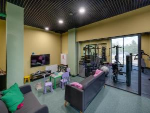 a living room with two couches and a gym at Holiday studio with balcony, indoor pool, sauna in Polanica-Zdrój