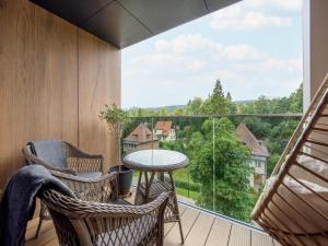 a balcony with chairs and a table and a large window at Holiday studio with balcony, indoor pool, sauna in Polanica-Zdrój