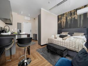 a bedroom with a king sized bed and a kitchen at Holiday studio with balcony, indoor pool, sauna in Polanica-Zdrój