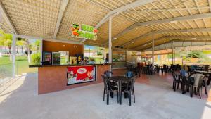 a restaurant with black chairs and tables and a bar at Caldas Park e Hotel - Caldas Novas in Caldas Novas