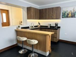 a kitchen with a counter and two stools at Anta lodge in Huaraz