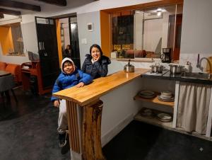 a woman and a child standing next to a counter at Anta lodge in Huaraz