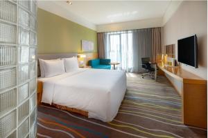 a hotel room with a white bed and a television at Holiday Inn Express Xi'an High-Tech Zone by IHG in Xi'an +57 photos