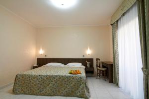 a hotel room with a bed with fruit on it at Hotel Primula in San Giovanni Rotondo