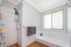 a white bathroom with a tub and a window at Waves And Moore - Beautifully presented home in Guilderton +37 photos