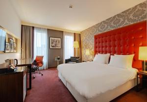 a hotel room with a large bed and a red headboard at Crowne Plaza Amsterdam - South by IHG in Amsterdam