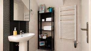 a bathroom with a sink and a shelf with towels at Deodonum Luxury Apartments in Heraklio +32 photos