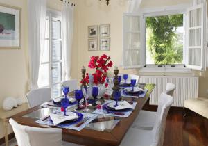 a dining room with a table and white chairs at Villa Casa Del Sol Syros in Parakopí