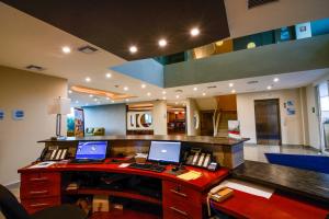 an office with two laptops on a desk with a phone at Holiday Inn Express Cabo San Lucas by IHG in Cabo San Lucas
