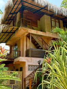 a house with stairs and a thatched roof at Salvia Madre Hotel Boutique in Guachaca