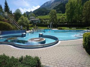 a large swimming pool with mountains in the background at Das Edelweiss in Hohentauern