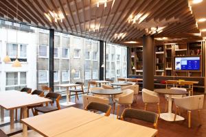 a restaurant with tables and chairs and large windows at Holiday Inn Express - Mülheim - Ruhr by IHG in Mülheim an der Ruhr