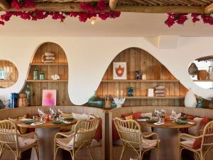 a restaurant with wooden walls and tables and chairs at Le Talaia Hôtel & Spa Biarritz - MGallery Collection in Biarritz
