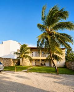 a palm tree in front of a building at Mar & Sol Preá - 700m da Praia - 12km de Jeri - 15km do Aeroporto in Prea +20 photos