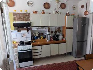 a kitchen with white cabinets and a stove and refrigerator at L Ecrin de Mussy in Mussy-sur-Seine