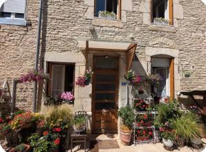 a building with potted plants in front of a door at L Ecrin de Mussy in Mussy-sur-Seine