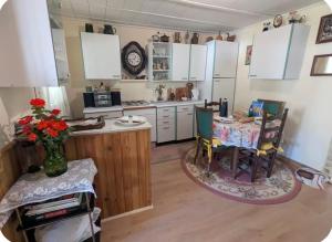 a kitchen with white cabinets and a table and chairs at L Ecrin de Mussy in Mussy-sur-Seine