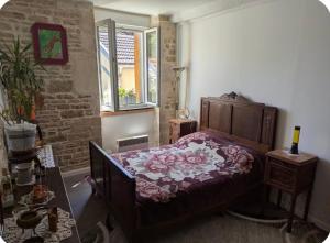a bedroom with a bed with a purple comforter at L Ecrin de Mussy in Mussy-sur-Seine
