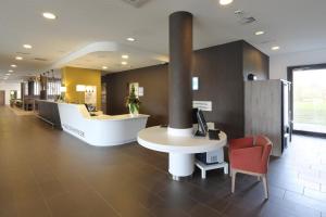 a lobby with a desk with a computer and a chair at Holiday Inn Express Friedrichshafen by IHG in Friedrichshafen